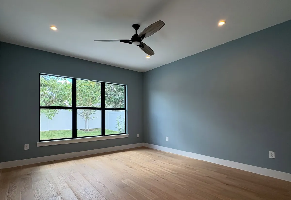 Design inspiration from another Florida home: bedroom with blue gray walls, oak floors and a black framed window