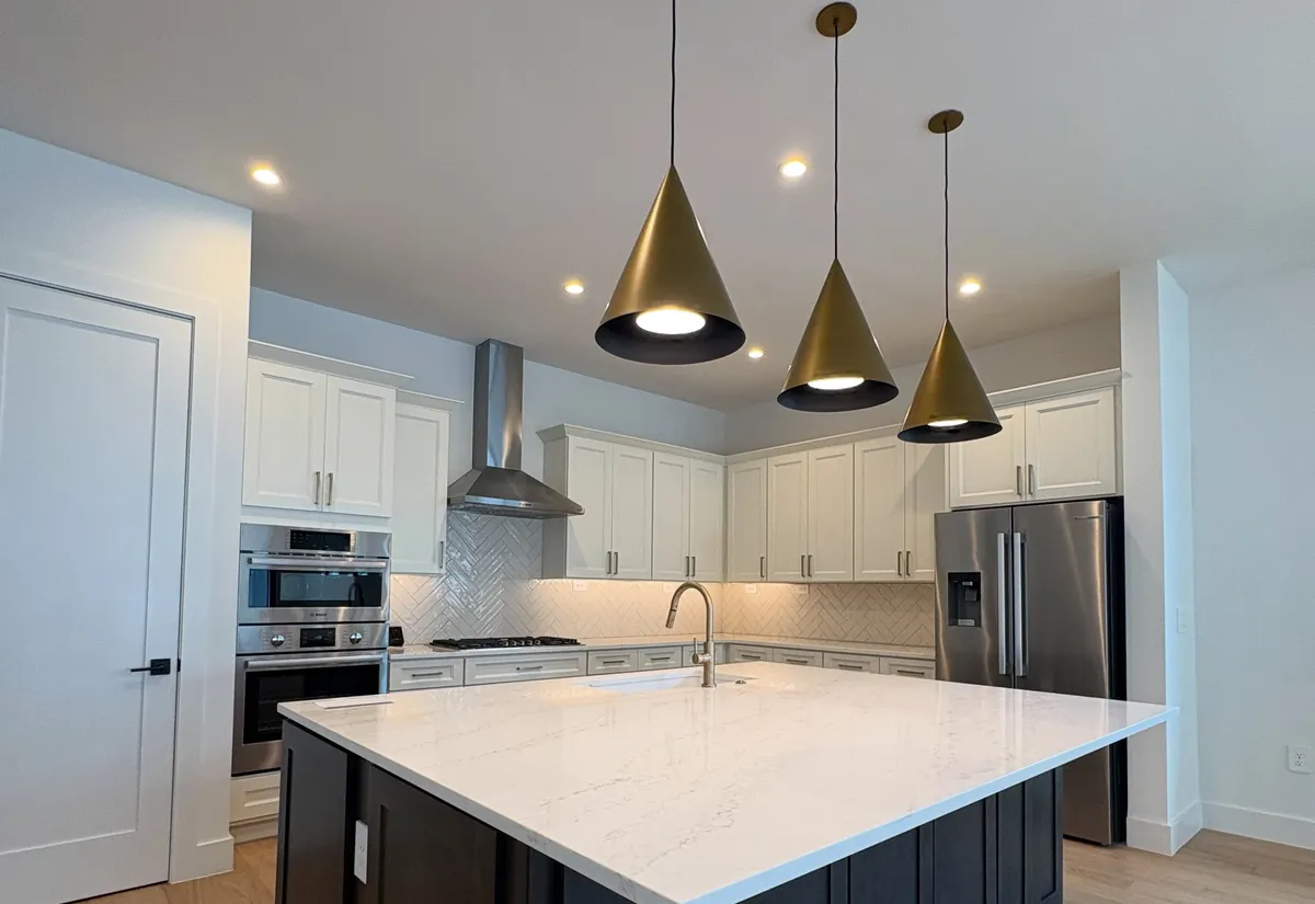 Design inspiration from another Florida home: kitchen with a dark island, white quartz top and brass pendant lights