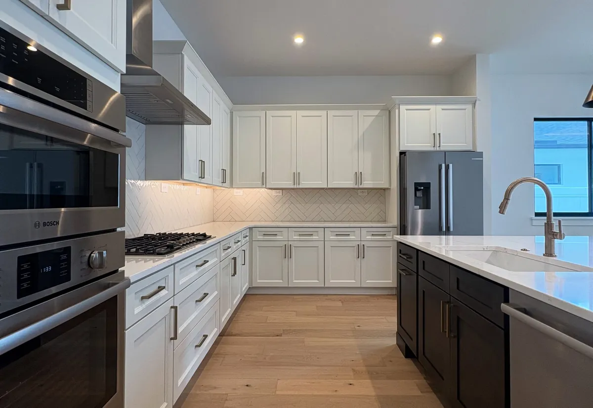 Design inspiration from another Florida home: white shaker kitchen with a herringbone backsplash and wide oak floors
