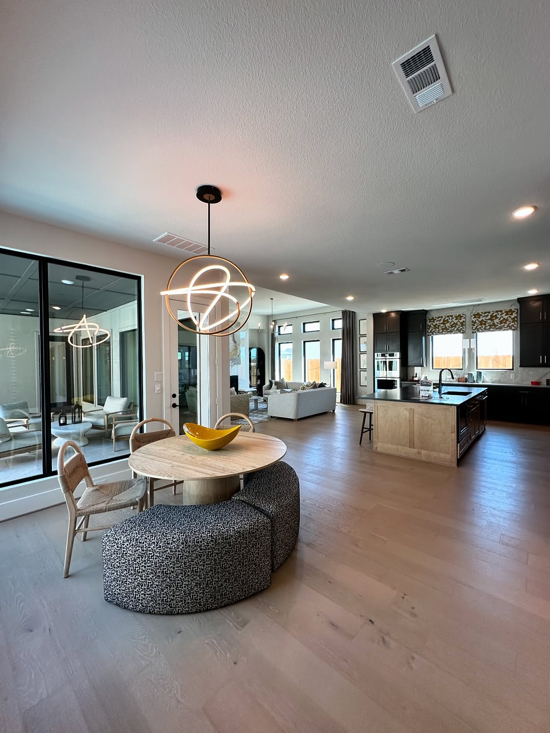 Open concept dining area with modern chandelier flowing into kitchen