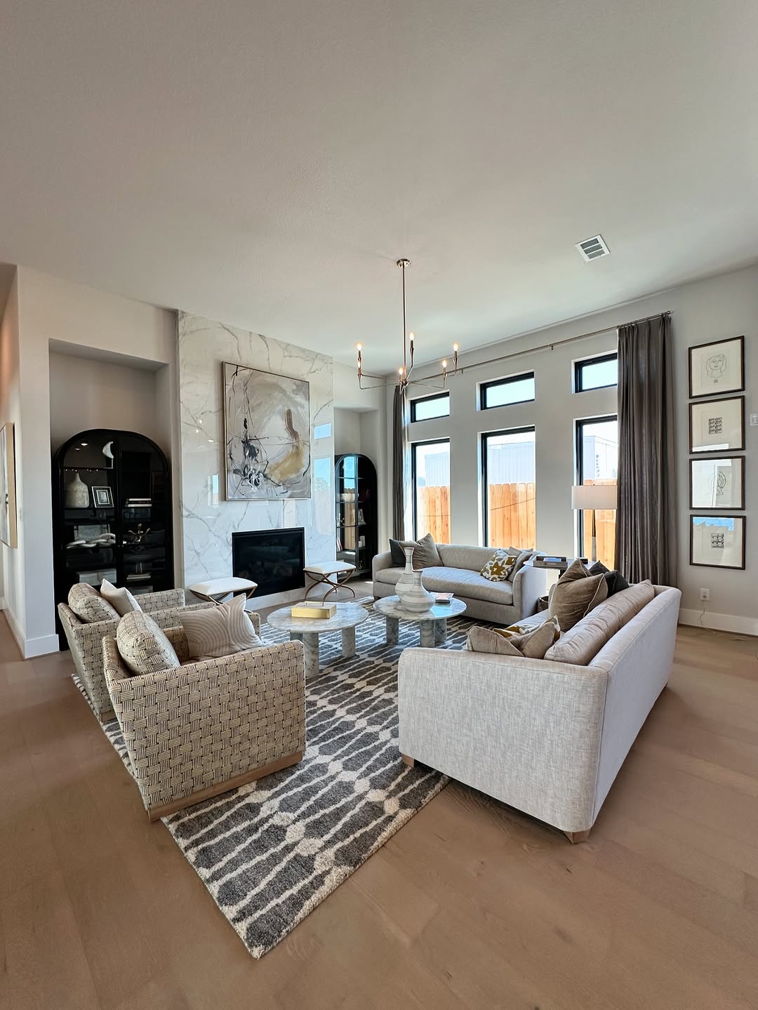 Living room with stone fireplace, chandelier, and arched built-in cabinet