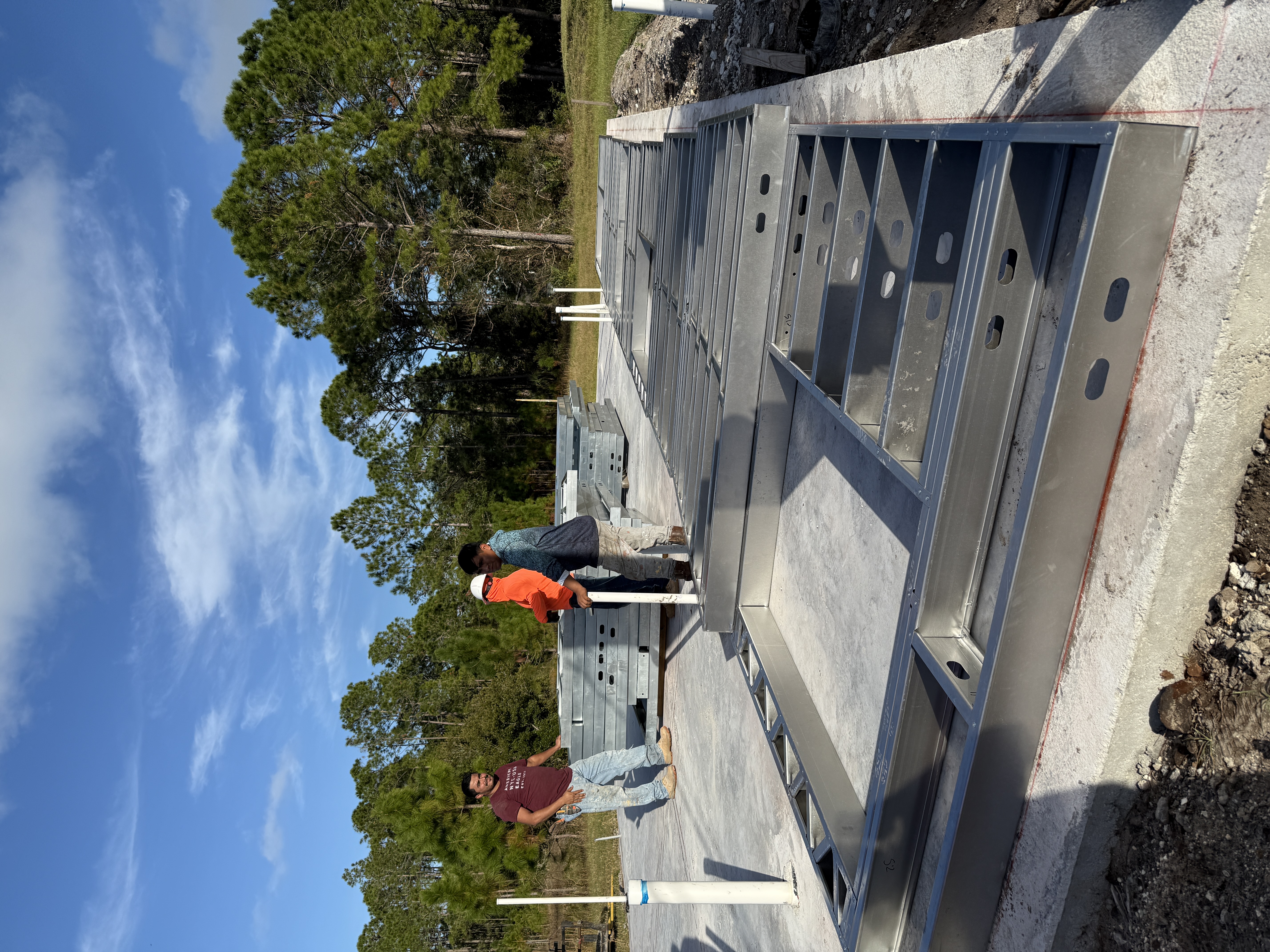 Construction crew assembling steel framing for custom home