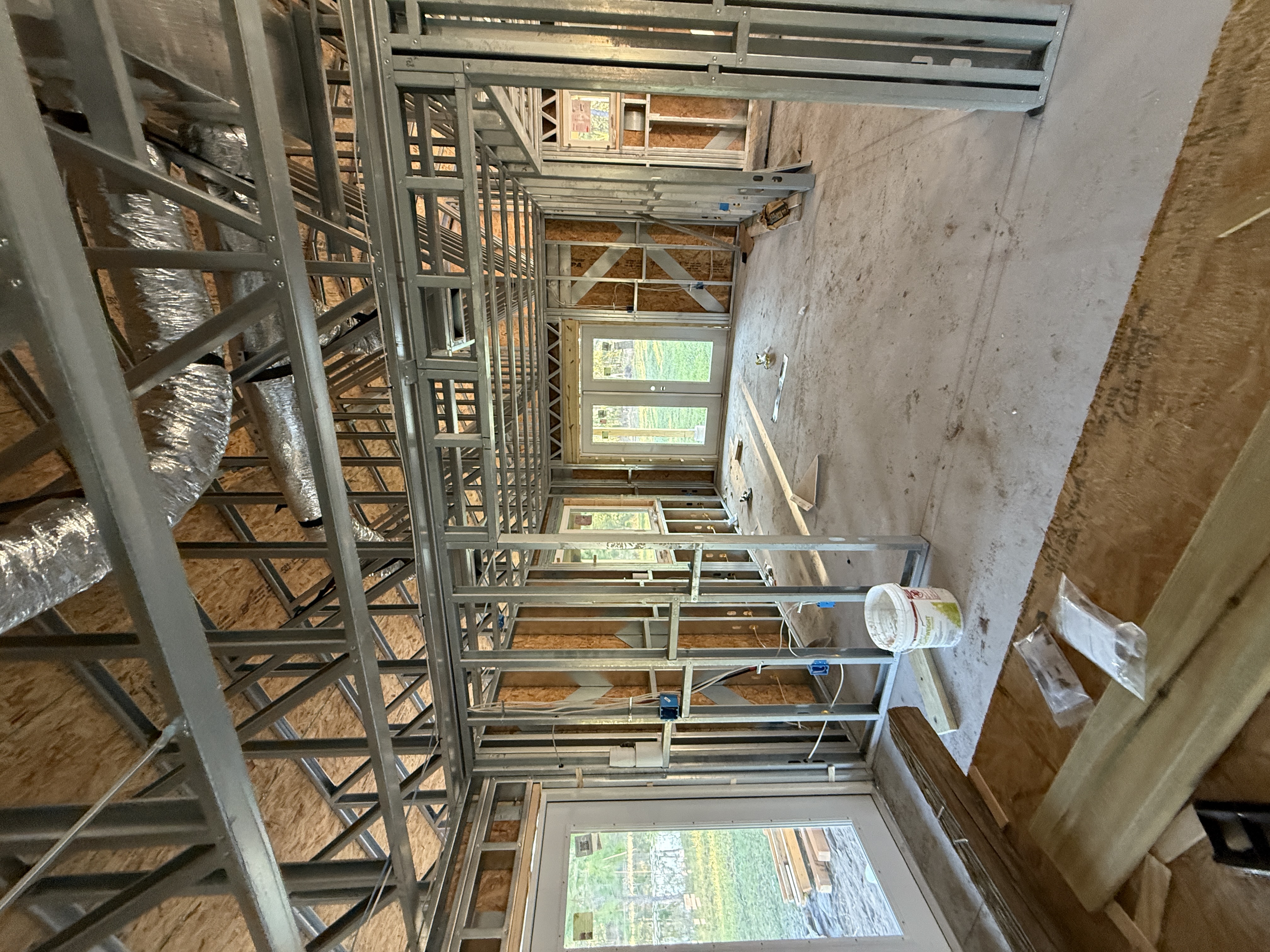 Interior rough-in phase showing HVAC and electrical in steel framing