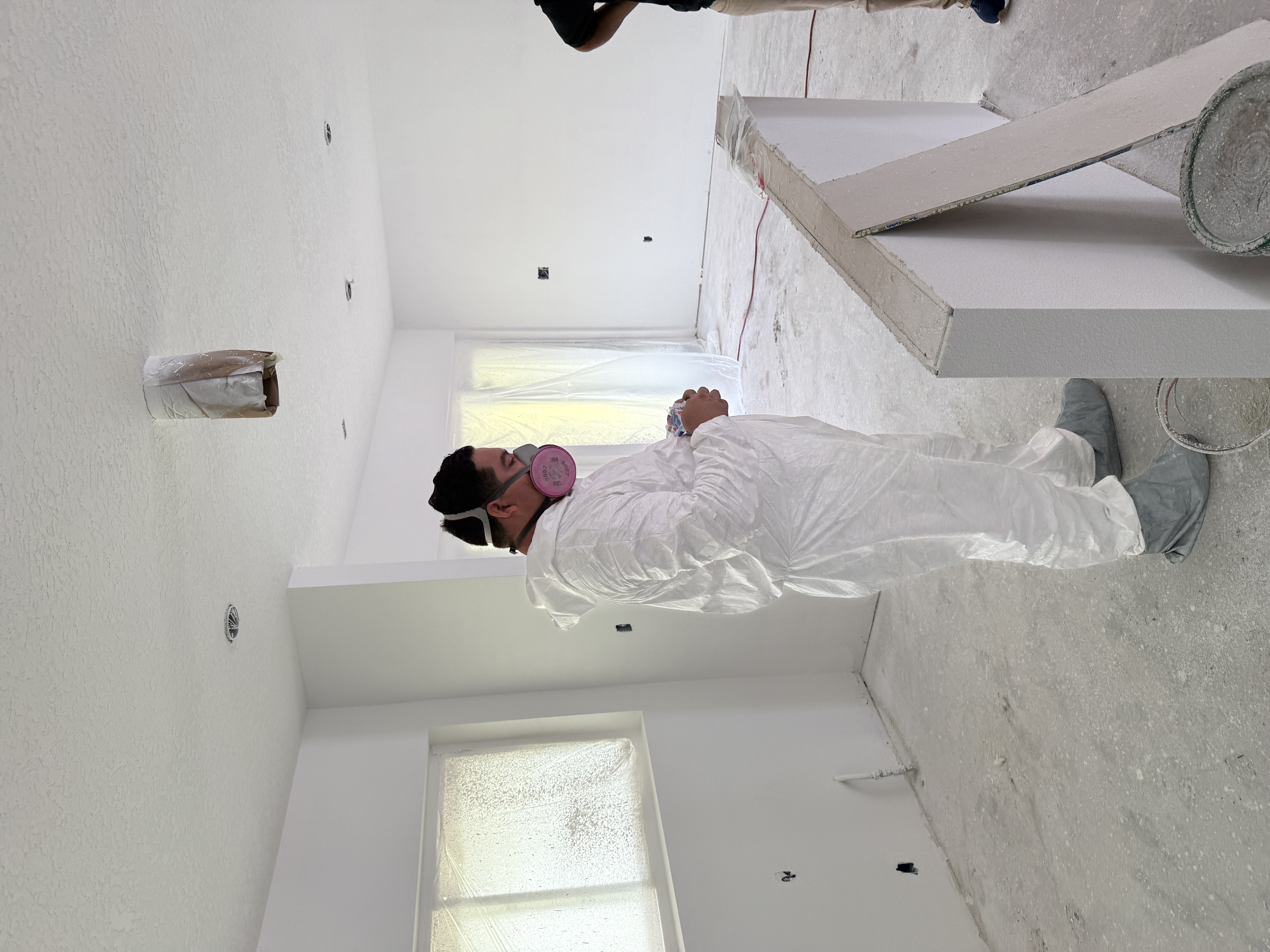 Painter working on a stairwell in a custom home
