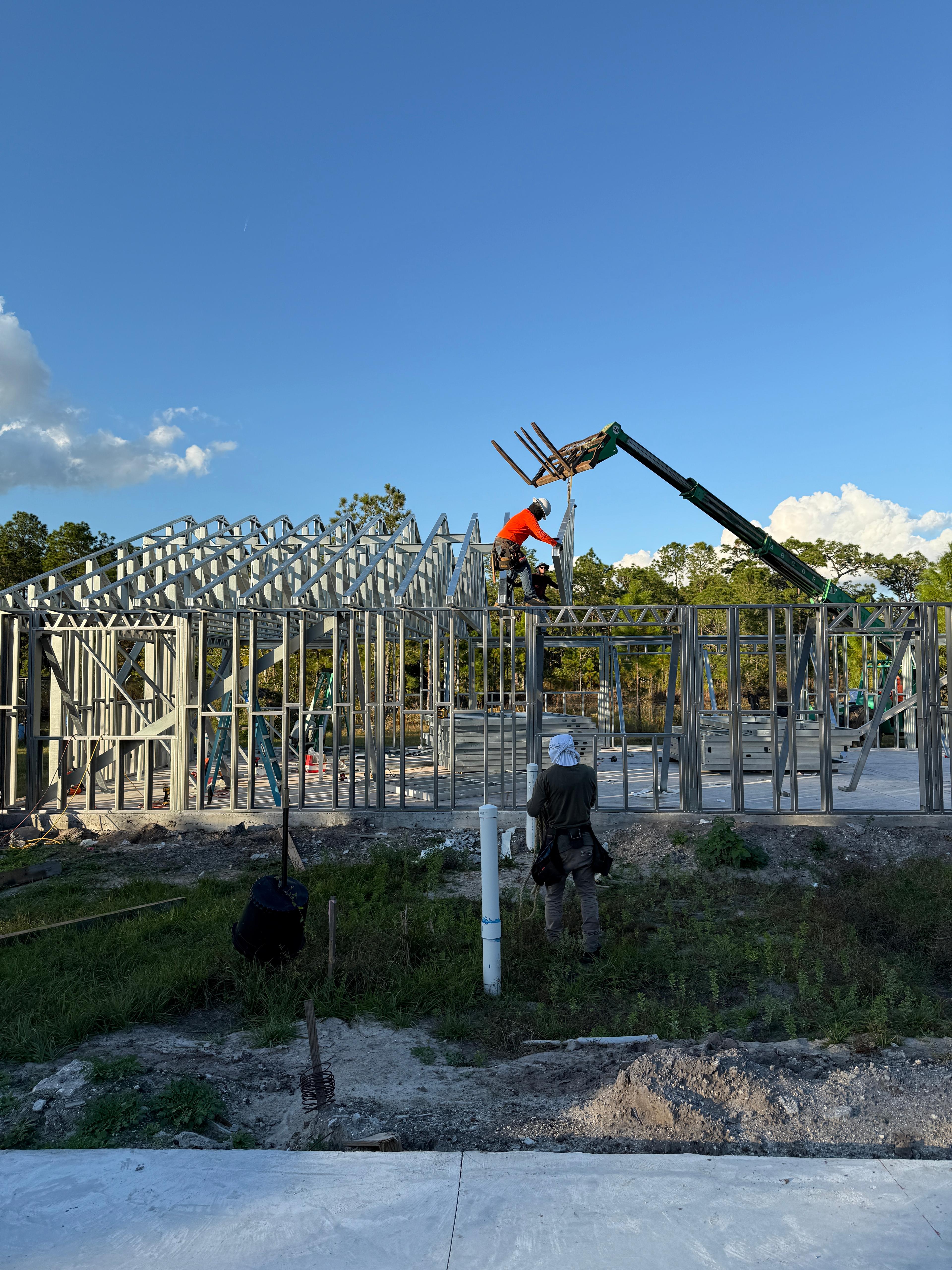 Steel frame being lifted into place by crane on a custom home build
