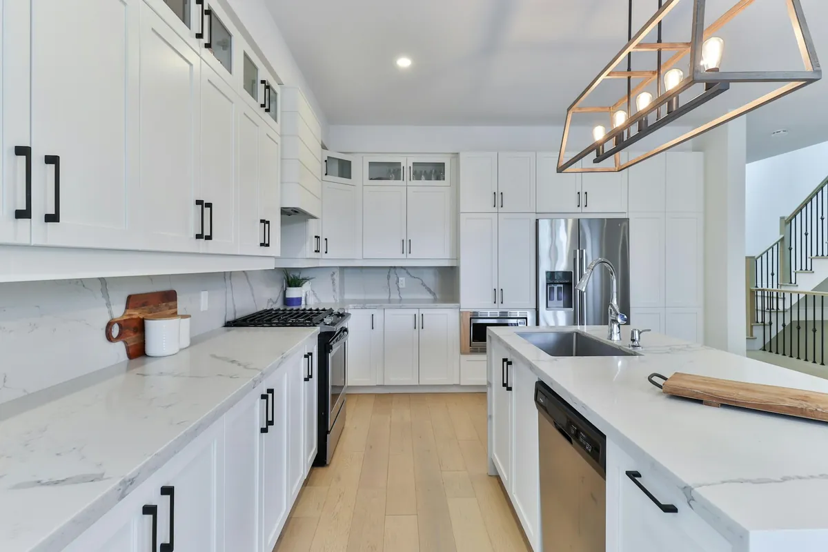 White shaker cabinet doors with black pulls in a bright kitchen