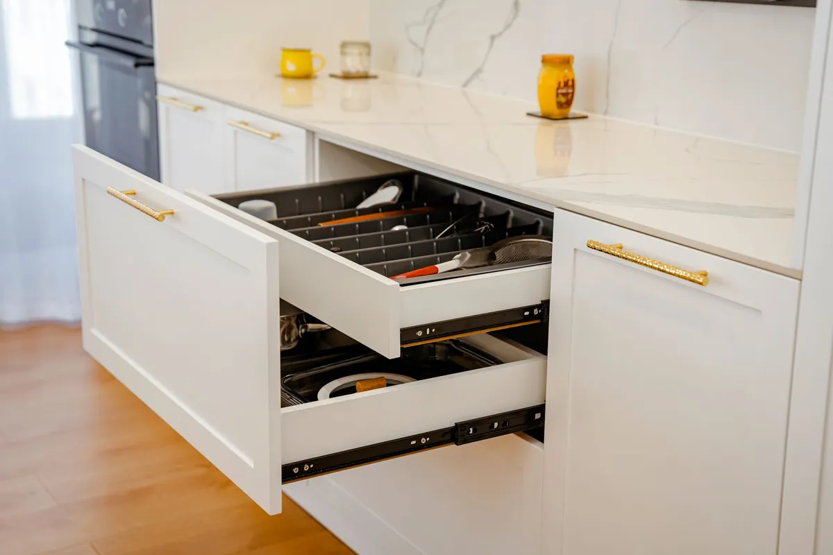 Open white drawers on full extension runners with a utensil organizer