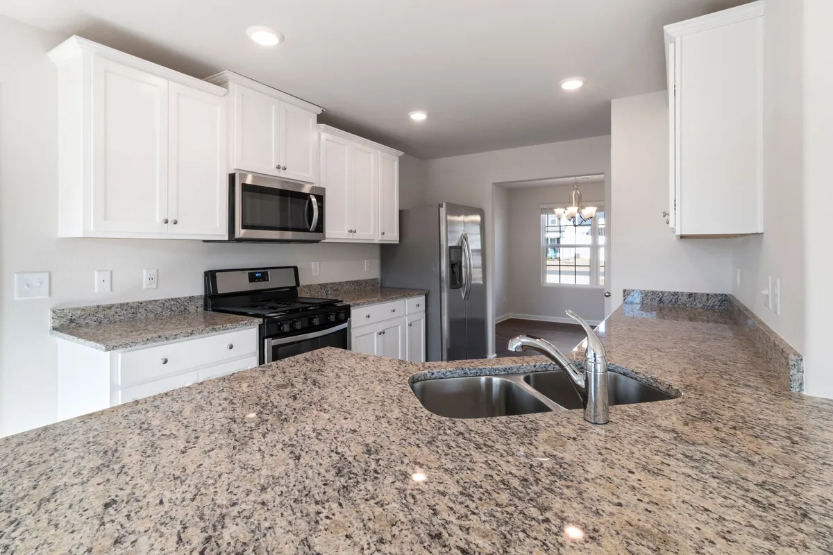 Speckled stone countertop with a double sink in a white kitchen