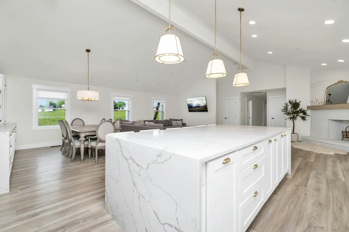 White waterfall island with bold gray veining under three pendant lights
