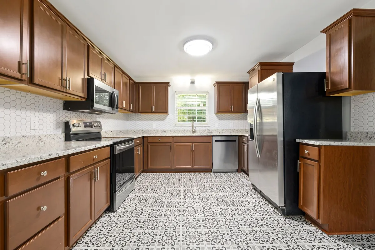 Gray and white patterned floor tile in a kitchen with wood cabinets