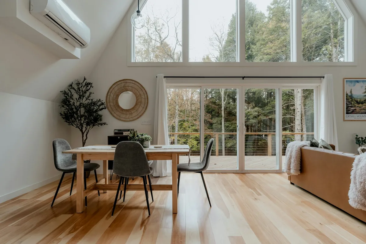Light wood plank floor in a sunlit dining area with tall windows