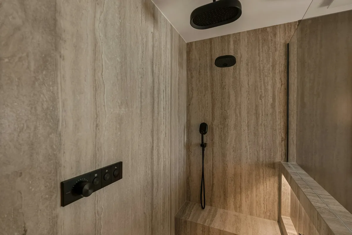 Shower with a ceiling rain head, a handheld sprayer and a digital control panel in matte black