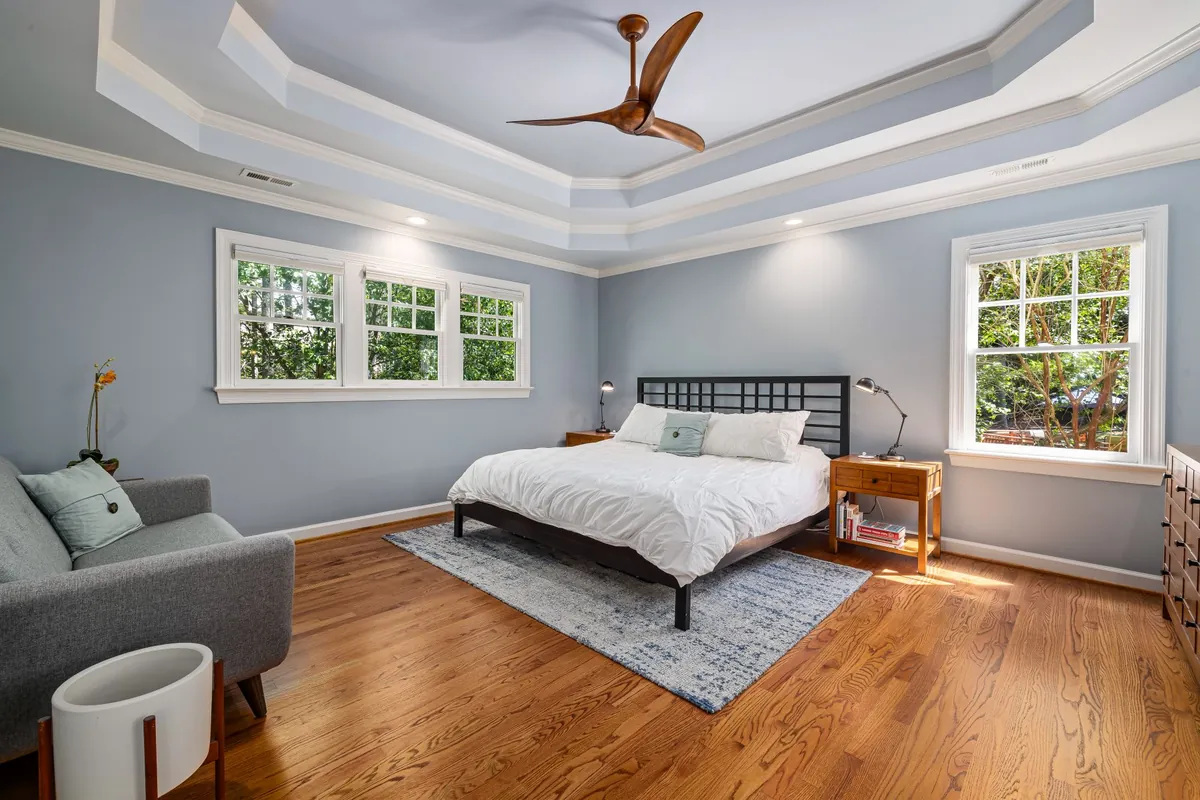 Bedroom with blue gray walls, white trim and a tray ceiling