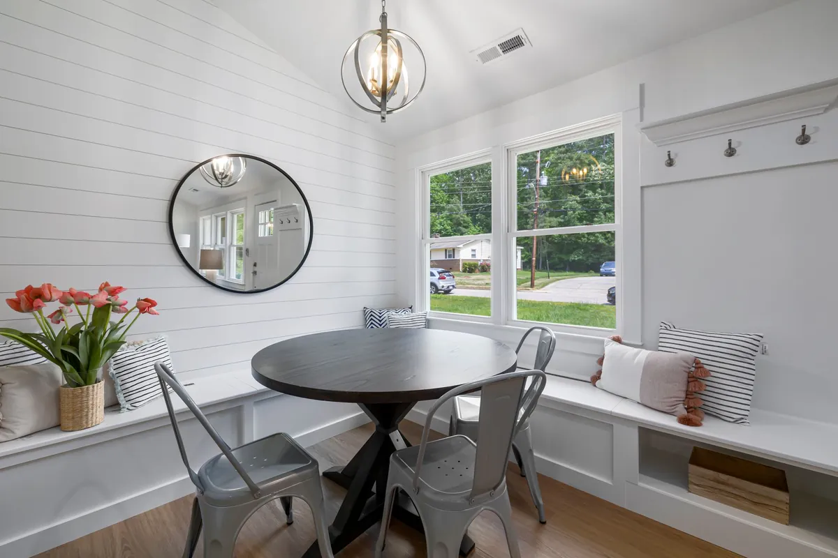 White horizontal shiplap wall in a breakfast nook with a round table