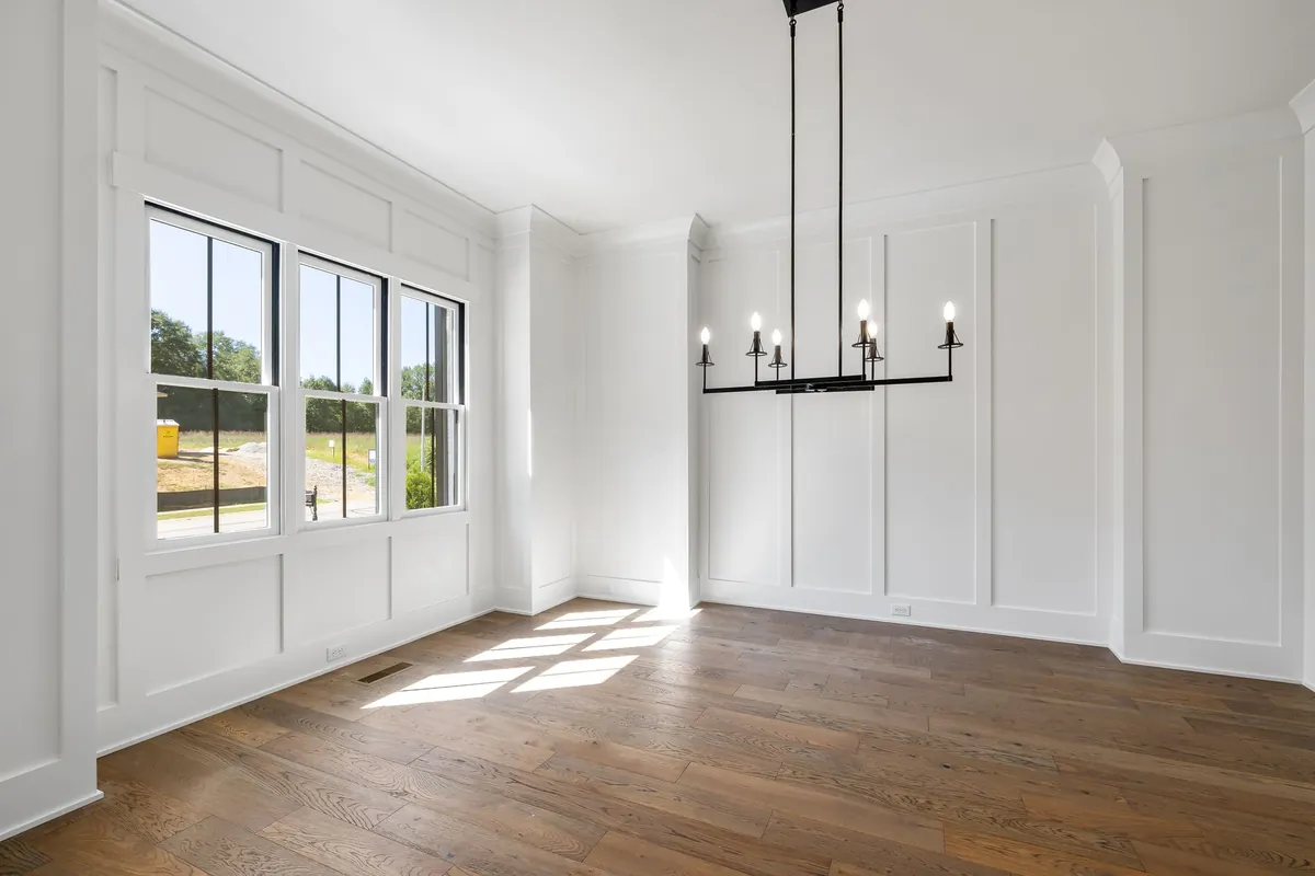 Full height white board and batten wall panels in a sunny dining room