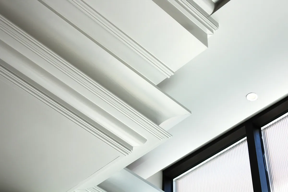 Close view of layered white crown molding along a ceiling