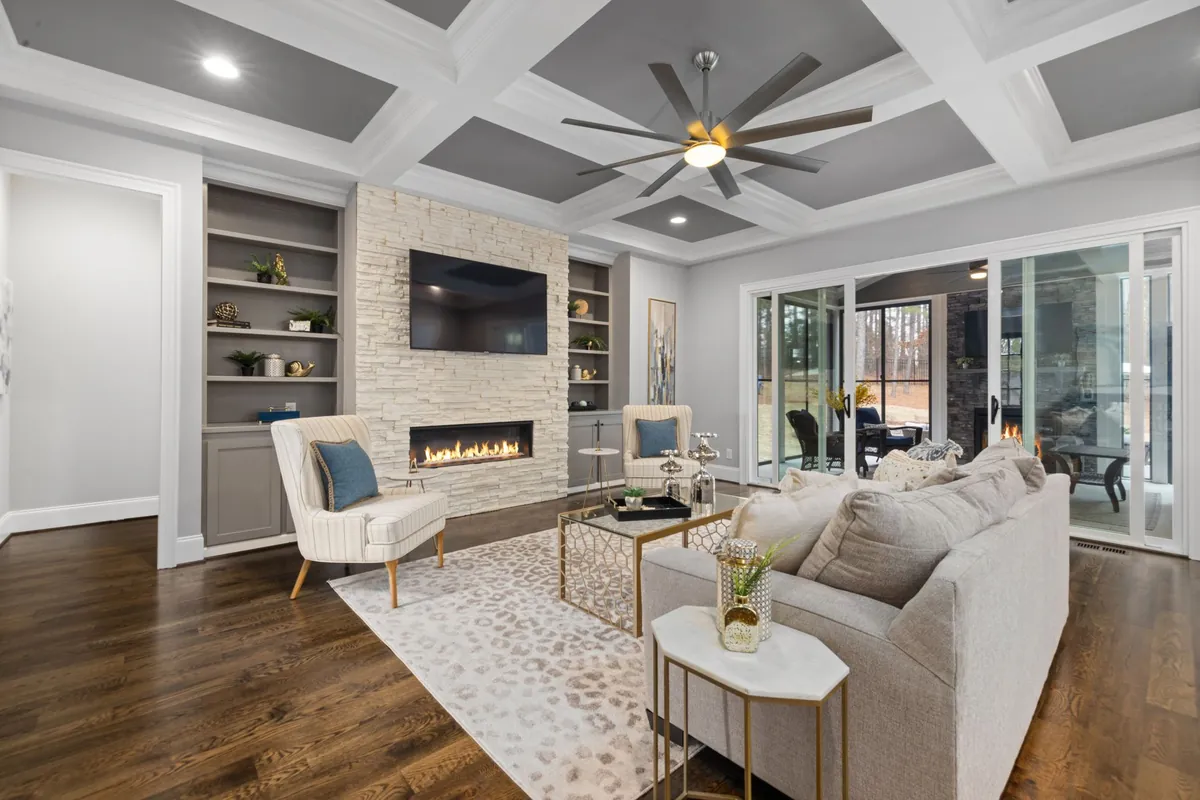 White coffered ceiling beams with gray panels over a living room with a fireplace
